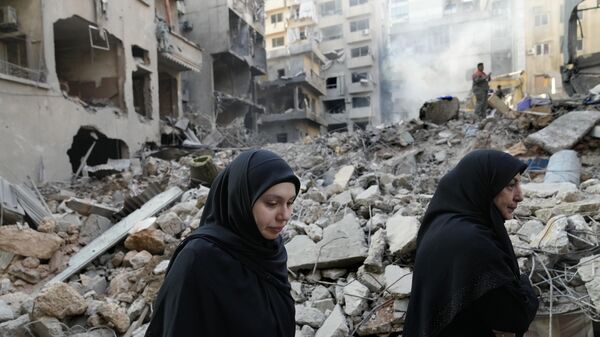 Lebanese women pass the destroyed buildings hit by an Israeli airstrike, in Beirut, Lebanon, Friday, Oct. 11, 2024.  - Sputnik International