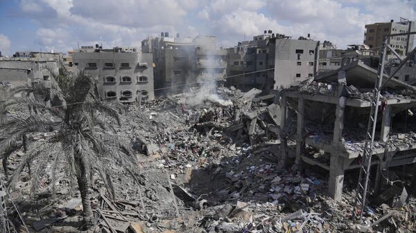 Palestinians search for the people killed in an Israeli airstrike in Bureij refugee camp Gaza Strip, Wednesday, Oct. 18, 2023 - Sputnik International