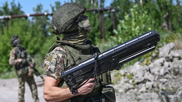 A Russian serviceman of the Tsentr Battlegroup holds an anti-drone gun  - Sputnik International