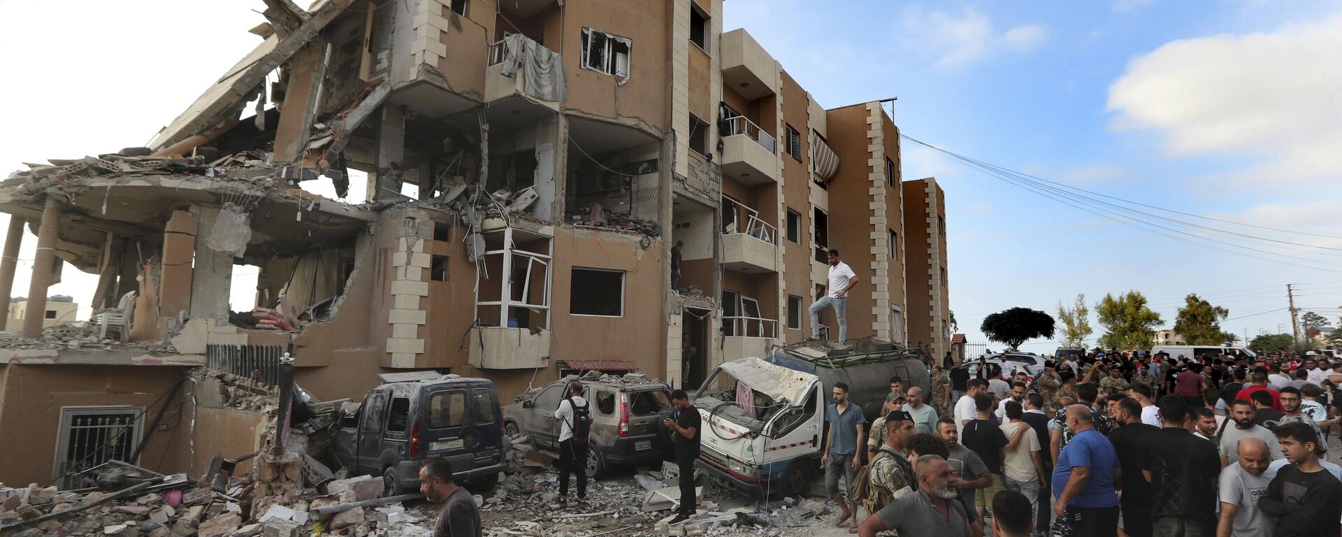 People gather next of a destroyed building hit by an Israeli airstrike, in Barja village, south of Beirut, Lebanon, Saturday, Oct. 12, 2024.  - Sputnik International, 1920, 13.10.2024