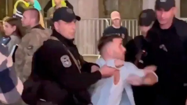 Screenshot of a conscription-age Ukrainian man struggling against armed police during a large-scale mobilization raid in Kiev, Ukraine. - Sputnik International