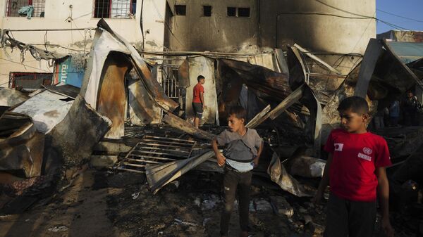 Palestinians look at the damage after an Israeli strike hit a tent area in the courtyard of Al Aqsa Martyrs hospital in Deir al Balah, Gaza Strip, Monday, Oct. 14, 2024 - Sputnik International