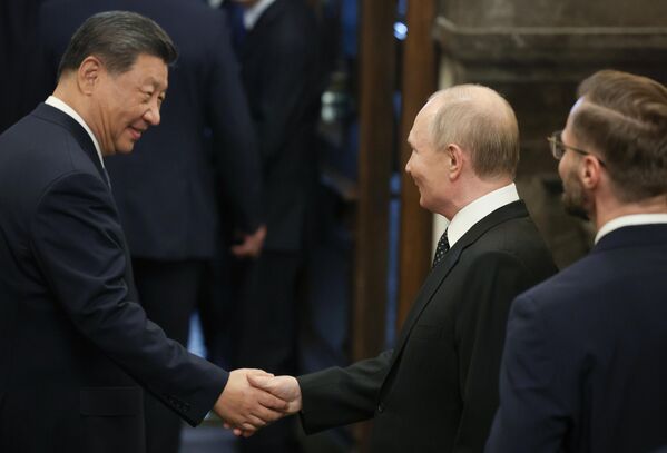 Russian President Vladimir Putin and Chinese President Xi Jinping speak after the informal dinner with the BRICS heads of delegations. - Sputnik International