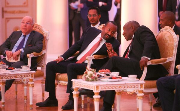 Ethiopian PM Abiy Ahmed Ali and South African President Cyril Ramaphosa lean in to chat during the concert prior to the informal dinner for BRICS heads of delegation, as Brazilian Foreign Minister Mauro Vieira, seated, looks on. - Sputnik International