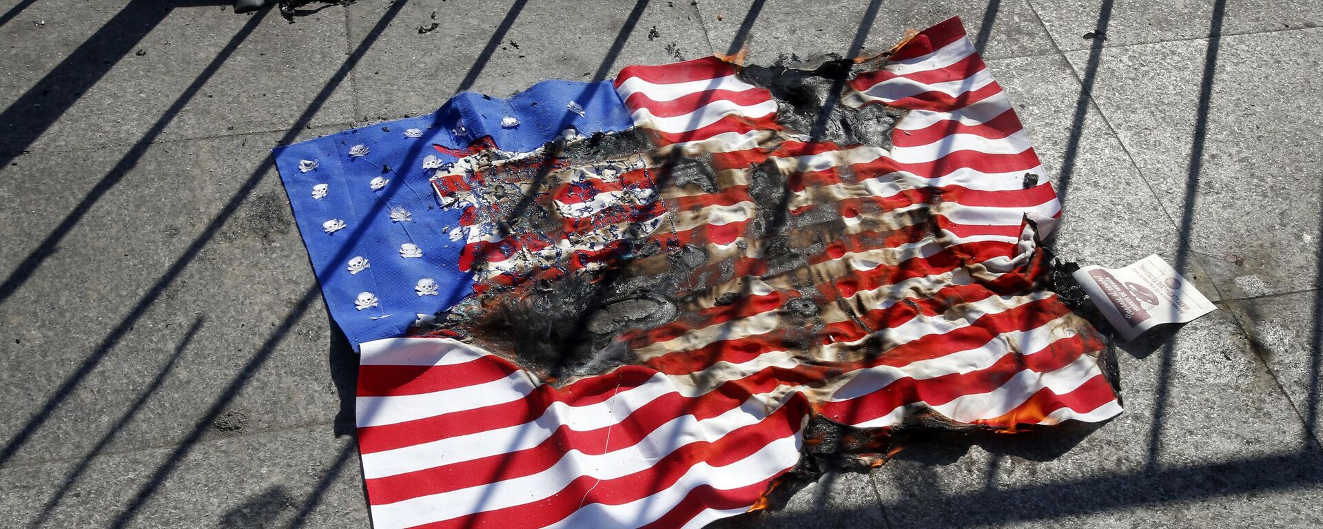 A burnt copy of a United Stated flag lays in front of the Palace of La Moneda, after it was lit by a single man to protest against the visit of US Vice President Mike Pence, in Santiago, Chile, Wednesday, Aug. 16, 2017 - Sputnik International, 1920, 25.10.2024