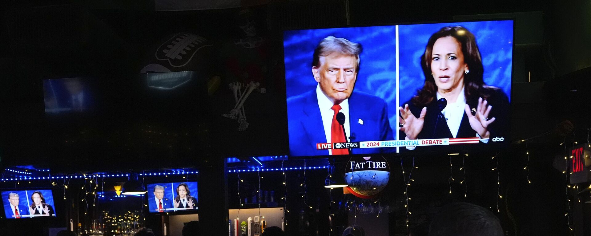 People watch TV screens showing a debate between Democratic presidential nominee Vice President Kamala Harris, right, and Republican presidential nominee former President Donald Trump, at Sports Grill Kendall, where the Miami-Dade Democratic Hispanic Caucus had organized a watch party, Tuesday, Sept. 10, 2024, in Miami.  - Sputnik International, 1920, 27.10.2024