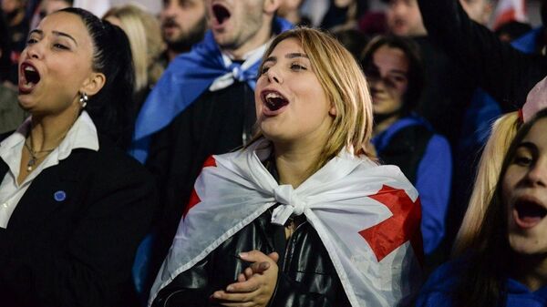 Supporters of Georgia's ruling Georgian Dream party celebrate the party's victory in parliamentary elections at a square outside the Georgian Dream office in Tbilisi, Georgia. - Sputnik International