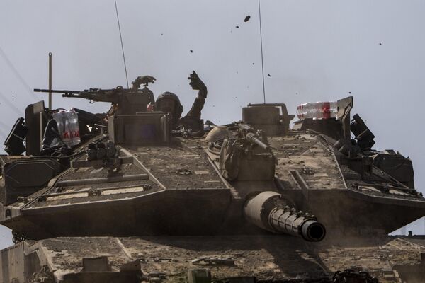 Israeli soldiers maneuver a tank along the border with the Gaza Strip. - Sputnik International