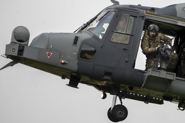 A British soldier is visible aboard a military helicopter during a NATO military exercise. - Sputnik International