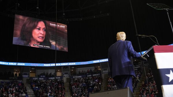 Republican presidential nominee former President Donald Trump watches a video of Democratic presidential nominee Vice President Kamala Harris as he speaks at a campaign rally at the Bryce Jordan Center, Saturday, Oct. 26, 2024, in State College, Pa. - Sputnik International