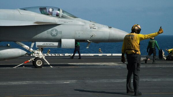 A crew member signals as a pilot prepares to launch an F/A-18 fighter jet on the deck of the USS Abraham Lincoln aircraft carrier in the Arabian Sea. 2019 file photo. The Lincoln is currently deployed in the Red Sea to assist in the US-led Operation Prosperity Guardian campaign against Yemen's Houthi militia - who have enforced a partial blockade of the Red Sea to Israeli-linked and allied merchant shipping. - Sputnik International