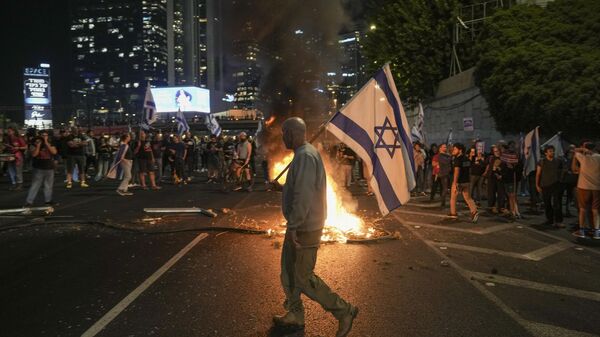 Israelis light a bonfire during a protest after Prime Minister Benjamin Netanyahu has dismissed his popular defense minister Yoav Gallant, in Tel Aviv, Israel, Tuesday, Nov. 5, 2024. - Sputnik International