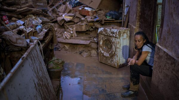 Maria Carmen, 54, sits next to her belongings outside her house after the floods in Paiporta, Valencia, Spain, Tuesday, Nov. 5, 2024.  - Sputnik International