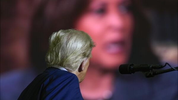 Republican presidential nominee former President Donald Trump watches a video featuring Democratic presidential nominee Vice President Kamala Harris as he speaks at a campaign rally at PPL Center, Tuesday, Oct. 29, 2024, in Allentown, Pa. - Sputnik International