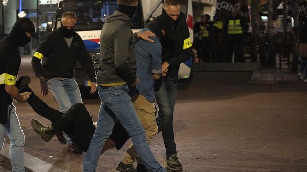 Police carry a demonstrator during a pro-Palestinian demonstration following a pro-Israeli commemoration  in Amsterdam, Netherlands. - Sputnik International