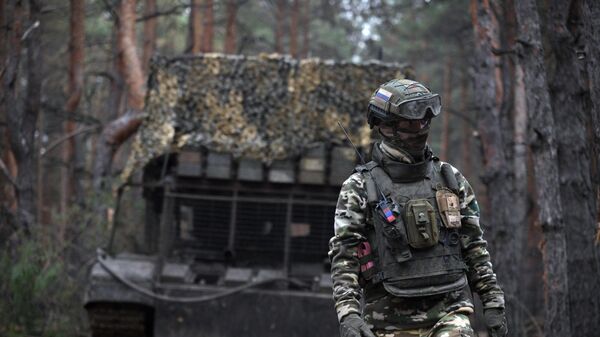 A Russian serviceman walks next to the TOS-1A Solntsepyok thermobaric rocket launcher at a position amid Russia's military operation. - Sputnik International