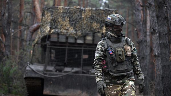 A Russian serviceman walks next to the TOS-1A Solntsepyok thermobaric rocket launcher at a position amid Russia's military operation. - Sputnik International