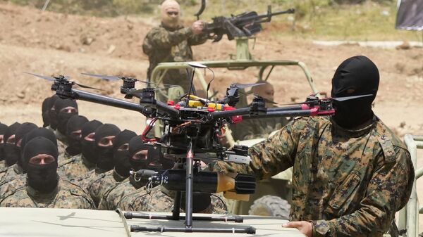 A Hezbollah fighter stands next to an armed drone during a training exercise in Aaramta village in the Jezzine District, southern Lebanon, on May 21, 2023 - Sputnik International