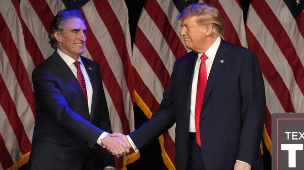 Donald Trump shakes hands with North Dakota Gov. Doug Burgum before he speaks at a caucus night rally in Las Vegas, Feb. 8, 2024.  - Sputnik International