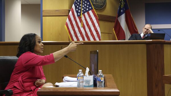 Fulton County District Attorney Fani Willis gestures while testifying as Fulton County Superior Judge Scott McAfee presides  during a hearing on the Georgia election interference case, Thursday, Feb. 15, 2024, in Atlanta. The hearing is to determine whether Willis should be removed from the case because of a relationship with Nathan Wade, special prosecutor she hired in the election interference case against former President Donald Trump. - Sputnik International