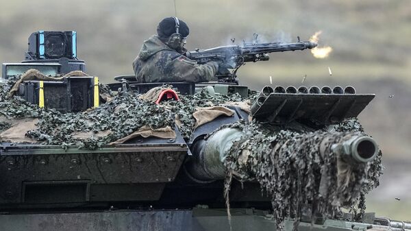 A soldier on a Leopard 2 tank fires during a visit of German Defense Minister Boris Pistorius at the Bundeswehr tank battalion 203 at the Field Marshal Rommel Barracks in Augustdorf, Germany, Wednesday, Feb. 1, 2023.  - Sputnik International