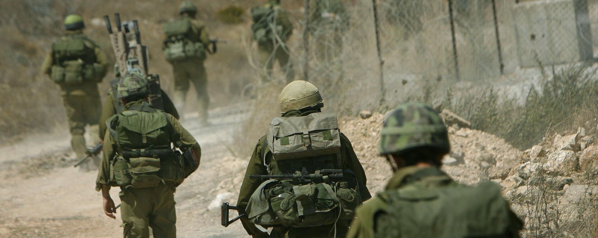 Israeli reservists walk along a dirt road on the Lebanon side of the border after crossing from northern Israel.  - Sputnik International, 1920, 24.12.2024