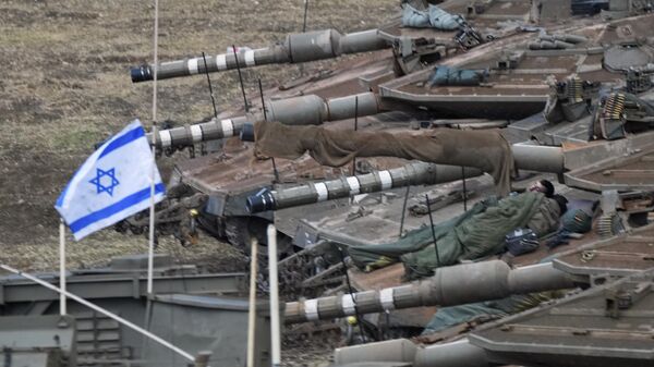 Israeli soldiers sleep on tanks in a staging area in northern Israel near the Israel-Lebanon border. - Sputnik International