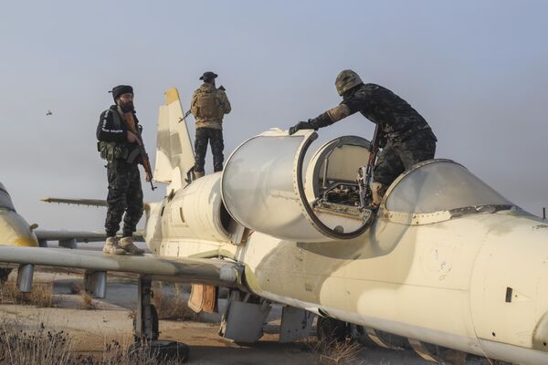 Tahrir al-Sham fighters stand on an aircraft at Al-Nayrab Military Airport after seizing control of the facility located on the outskirts of Aleppo. - Sputnik International