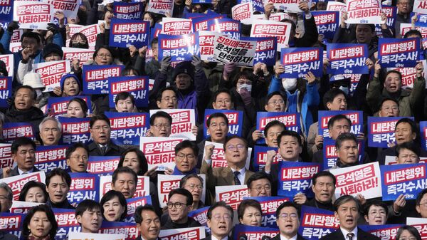 South Korea's main opposition Democratic Party leader Lee Jae-myung, bottom center, shout slogans during a rally against President Yoon Suk Yeol at the National Assembly in Seoul, South Korea, Wednesday, Dec. 4, 2024. The signs read Yoon Suk Yeol should resign. - Sputnik International