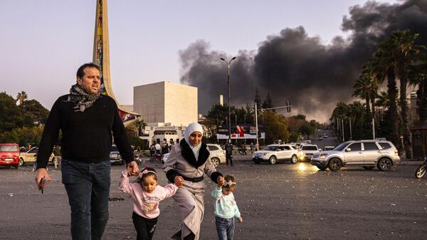 Smoke billows as people arrive to celebrate the fall of the Syrian government, in Damascus - Sputnik International