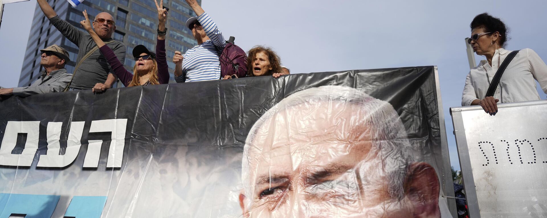 Supporters of Israel's Prime Minster Benjamin Netanyahu, seen in poster, gather outside a  court in Tel Aviv, Israel, Tuesday, Dec. 10, 2024 as Netanyahu is set to take the stand in his long-running trial on corruption charges. - Sputnik International, 1920, 10.12.2024