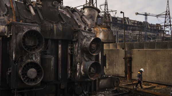 A worker walks in front of a transformer which was destroyed after a recent Russian missile attack at DTEK's power plant in Ukraine, Nov. 28, 2024. - Sputnik International