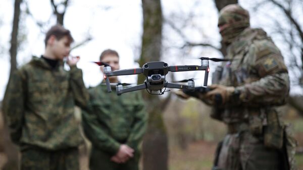 An instructor teaches how to use a drone during preliminary military training - Sputnik International