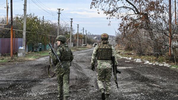 Russian soldiers walk along a road in the town of Selidovo in the DPR. - Sputnik International