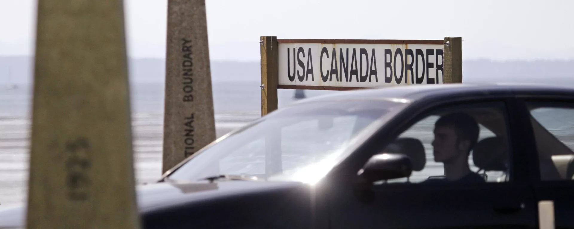 A driver headed toward the U.S. passes border markers Saturday, May 30, 2009, at the border crossing between the U.S. and Canada - Sputnik International, 1920, 18.12.2024