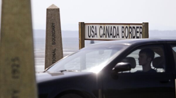 A driver headed toward the U.S. passes border markers Saturday, May 30, 2009, at the border crossing between the U.S. and Canada - Sputnik International