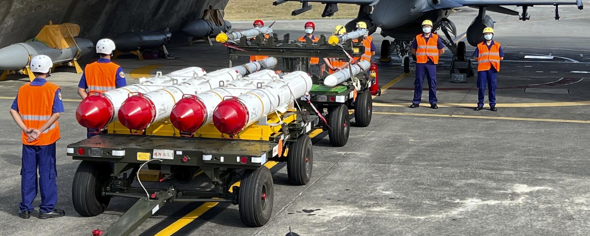 Military personnel stand next to U.S. Harpoon A-84, anti-ship missiles and AIM-120 and AIM-9 air-to-air missiles prepared for a weapon loading drills in front of a U.S. F-16V fighter jet at the Hualien Airbase in Taiwan's southeastern Hualien county, Wednesday, Aug. 17, 2022.  - Sputnik International, 1920, 21.12.2024