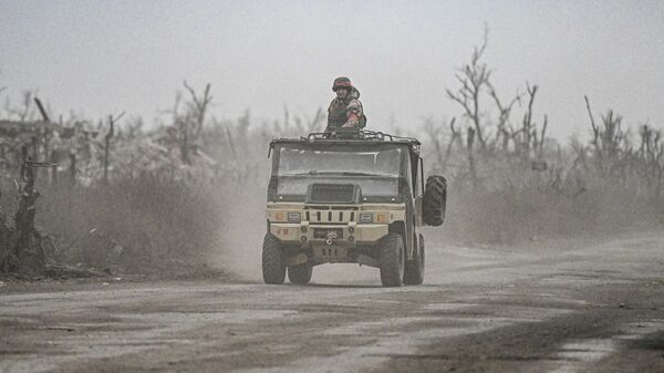 Russian servicemen drive a vehicle in the village of Karlovka, controlled by Russian armed forces, near Krasnoarmeysk  - Sputnik International