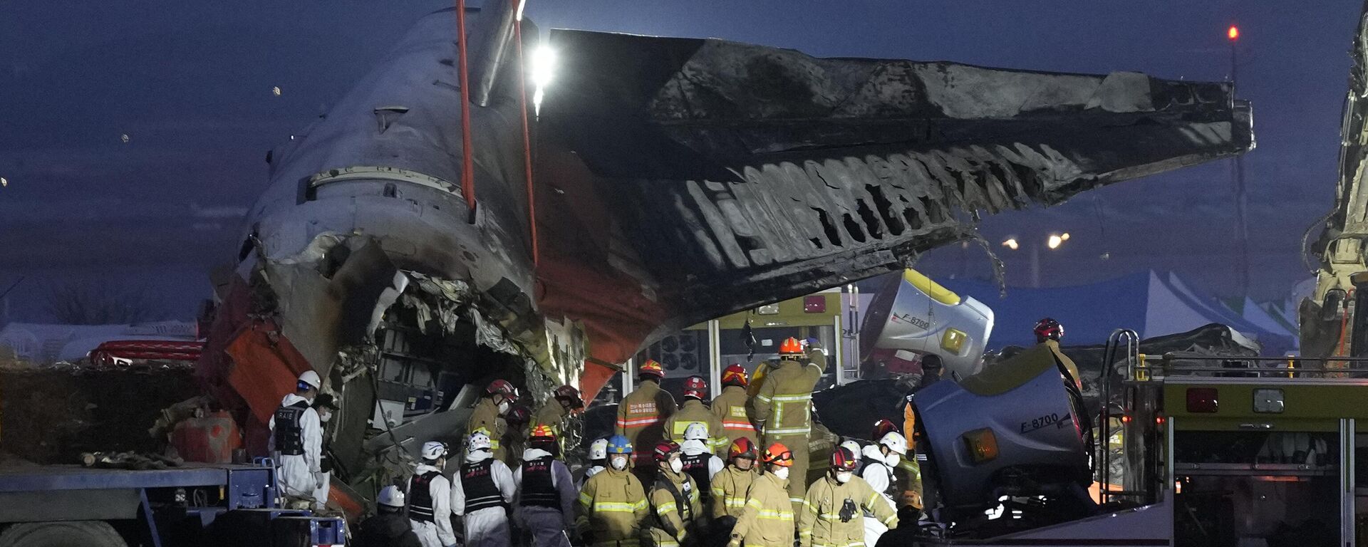 Rescue team carry the body of a passenger at the site of a plane fire at Muan International Airport in Muan, South Korea, Sunday, Dec. 29, 2024. - Sputnik International, 1920, 29.12.2024