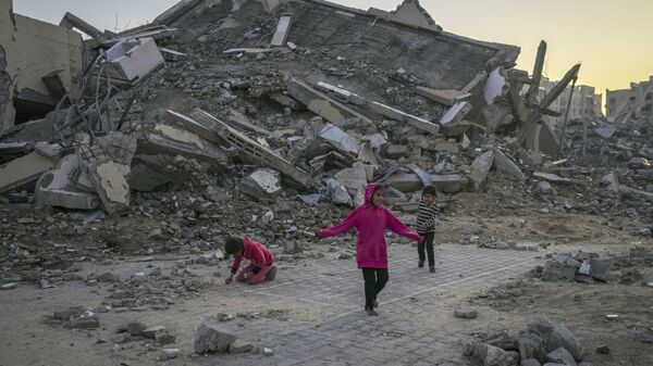 Palestinian children next to a building destroyed by Israeli army strikes in the central Gaza Strip town of Khan Younis, Wednesday, Jan. 1, 2025. - Sputnik International