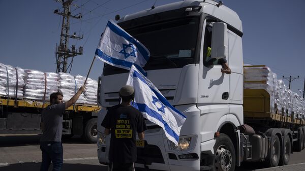 Activists stand in front of trucks carrying humanitarian aid as they try to stop them from entering the Gaza Strip in an area near the Kerem Shalom border crossing, southern Israel, Thursday, May 9, 2024.  - Sputnik International