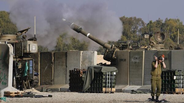 An Israeli soldier covers his ears as an artillery gunner fires into the Gaza Strip from a position in southern Israel, Thursday, Jan. 2, 2025. - Sputnik International