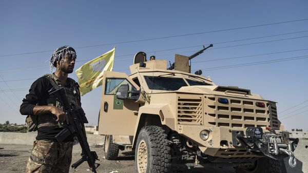 A U.S.-backed Syrian Democratic Forces (SDF) fighter stands next an armored vehicle, at al-Sabha town in the eastern countryside of Deir el-Zour, Syria, Monday, Sept. 4, 2023.  - Sputnik International