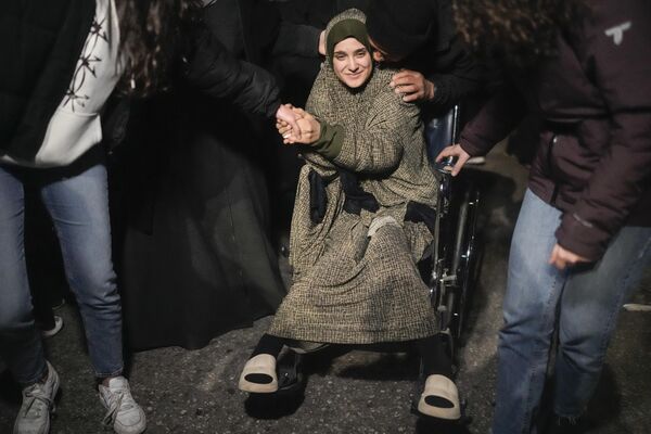 A wheelchair-bound Palestinian prisoner is greeted after disembarking from a bus following her release from an Israeli jail in Beitunia, the West Bank. - Sputnik International