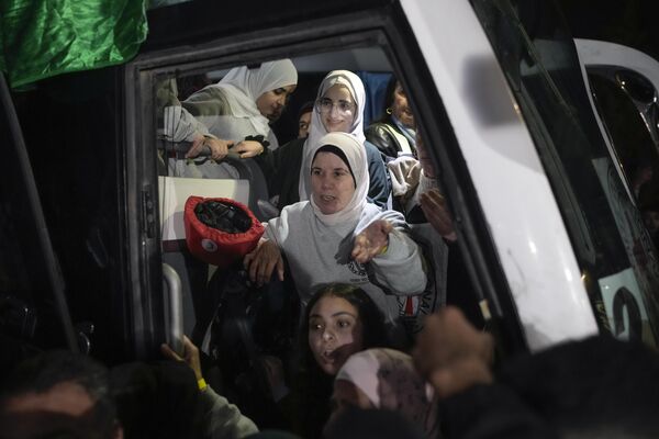 Female Palestinian prisoners disembark from a bus after being released from an Israeli prison, in the West Bank city of Beitunia. - Sputnik International