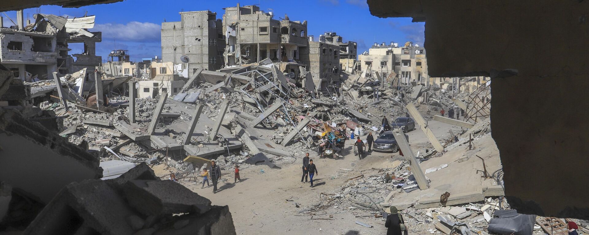 Palestinians walk through the rubble caused by the Israeli air and ground offensive in Rafah, southern Gaza Strip, Monday, Jan. 20, 2025. - Sputnik International, 1920, 20.01.2025