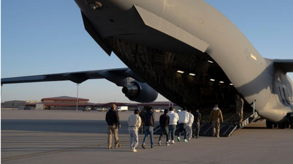 Screenshot of image showing U.S. Customs and Border Protection security agents guide a group of migrants to board a C-17 Globemaster III aircraft assigned to the 60th Air Mobility Wing for a removal flight at Fort Bliss, Texas, on Jan. 23, 2025.  - Sputnik International