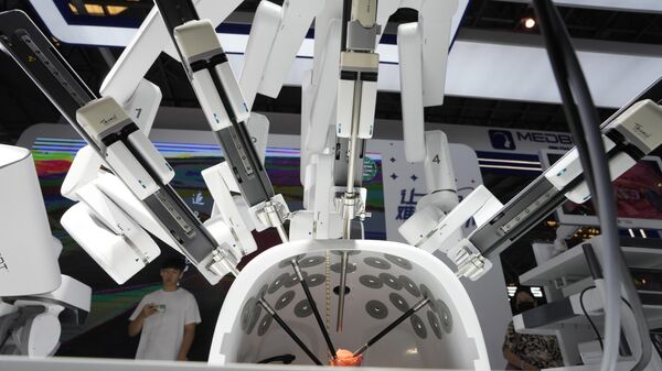 A visitor stand near a robotic surgeon from Chinese firm Medrobot demonstrating its skills on a rose during the 2023 World Artificial Intelligence Conference in Shanghai, Thursday, July 6, 2023. - Sputnik International