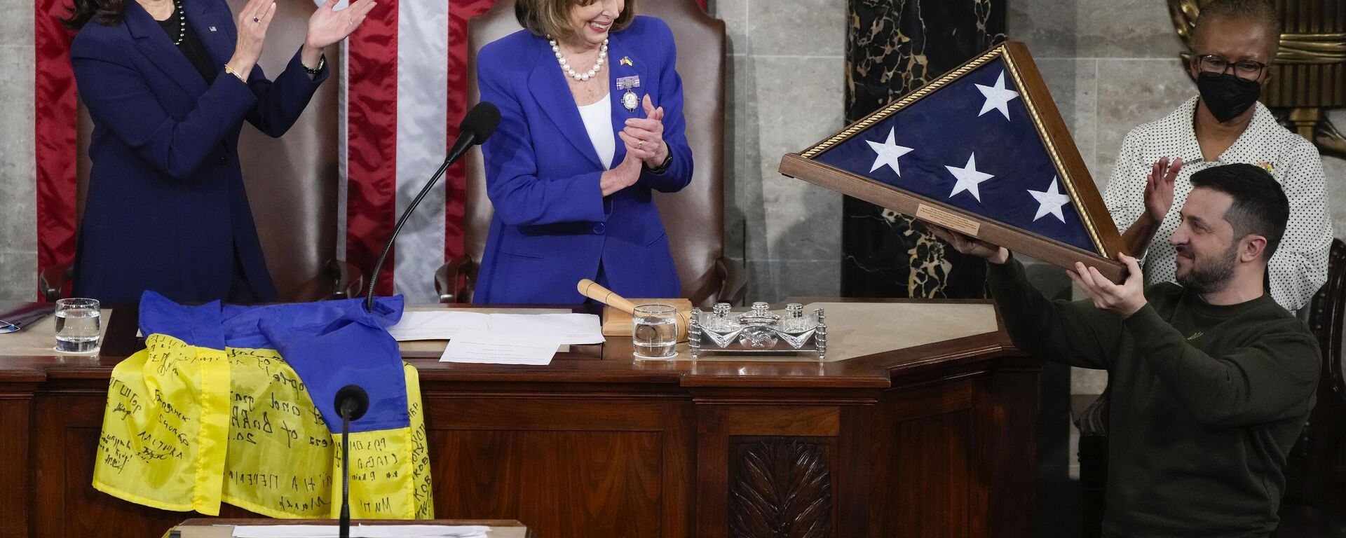 Ukrainian President Volodymyr Zelenskyy, right, holds up an American flag that was gifted to him by House Speaker Nancy Pelosi of Calif., and Vice President Kamala Harris, after he addressed a joint meeting of Congress on Capitol Hill in Washington, Wednesday, Dec. 21, 2022. - Sputnik International, 1920, 12.02.2025