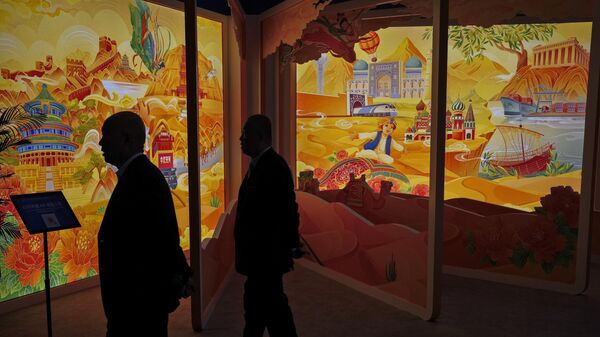 Attendees are silhouetted as they pass by an art display depicting China's Belt and Road Initiative at the China National Convention Center in Beijing, Wednesday, Oct. 18, 2023.  - Sputnik International